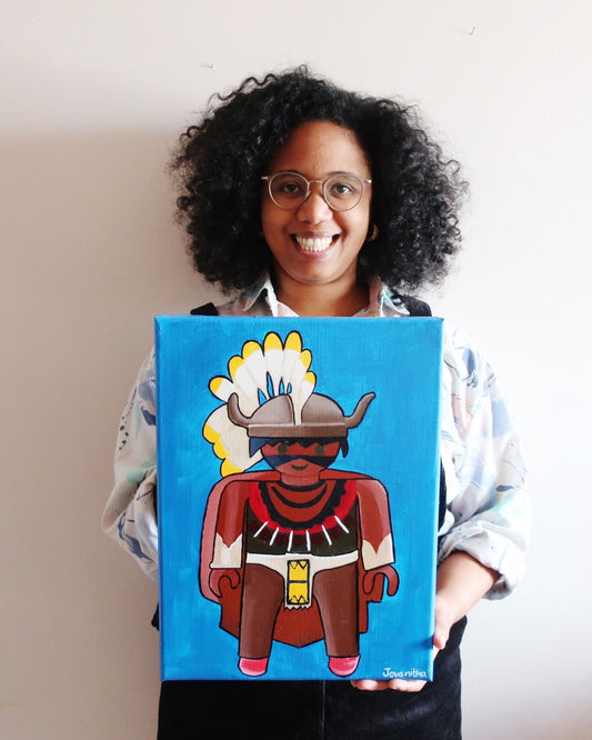 A black woman holding an oil painting of an Indian Playmobil against a blue background