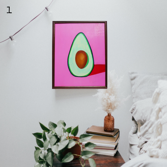 An oil painting of a green avocado on a pink background in a thrifted frame in a boho decor