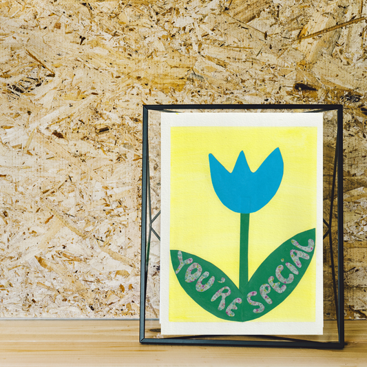 A black framed collage of a blue tulip with the words you're special written on its green leaves
