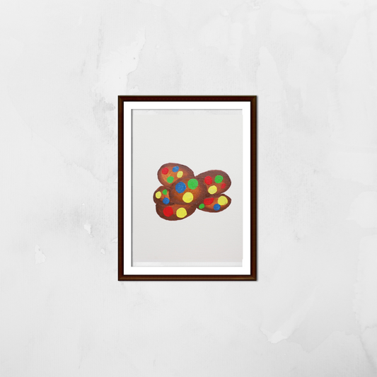 A framed painting of chocolate cookies with colourful M&Ms on a white wall
