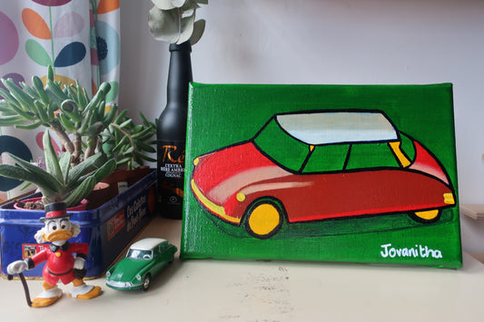 An oil painting of a red Citroen DS car against a green background on a white shelf