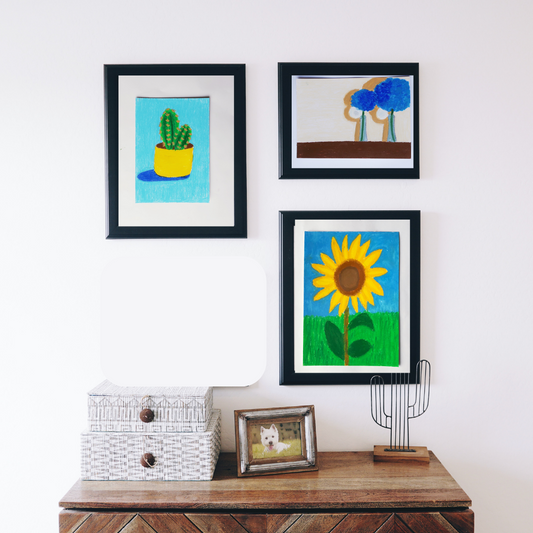 Three black framed oil pastel paintings of flowers in a boho decor