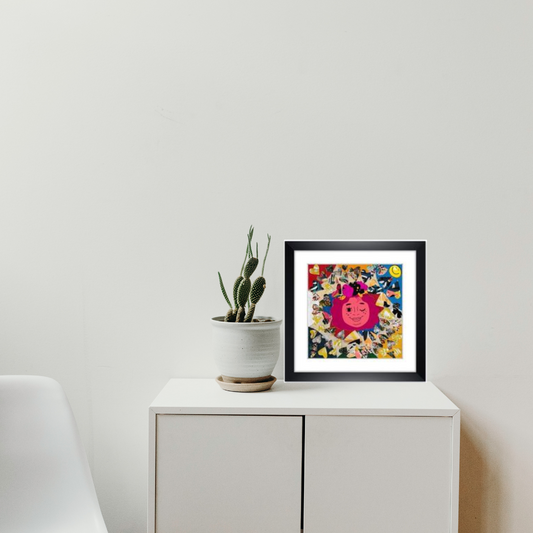 A black framed print of a happy art of a collage of Queen surrounded by hearts on a white cabinet