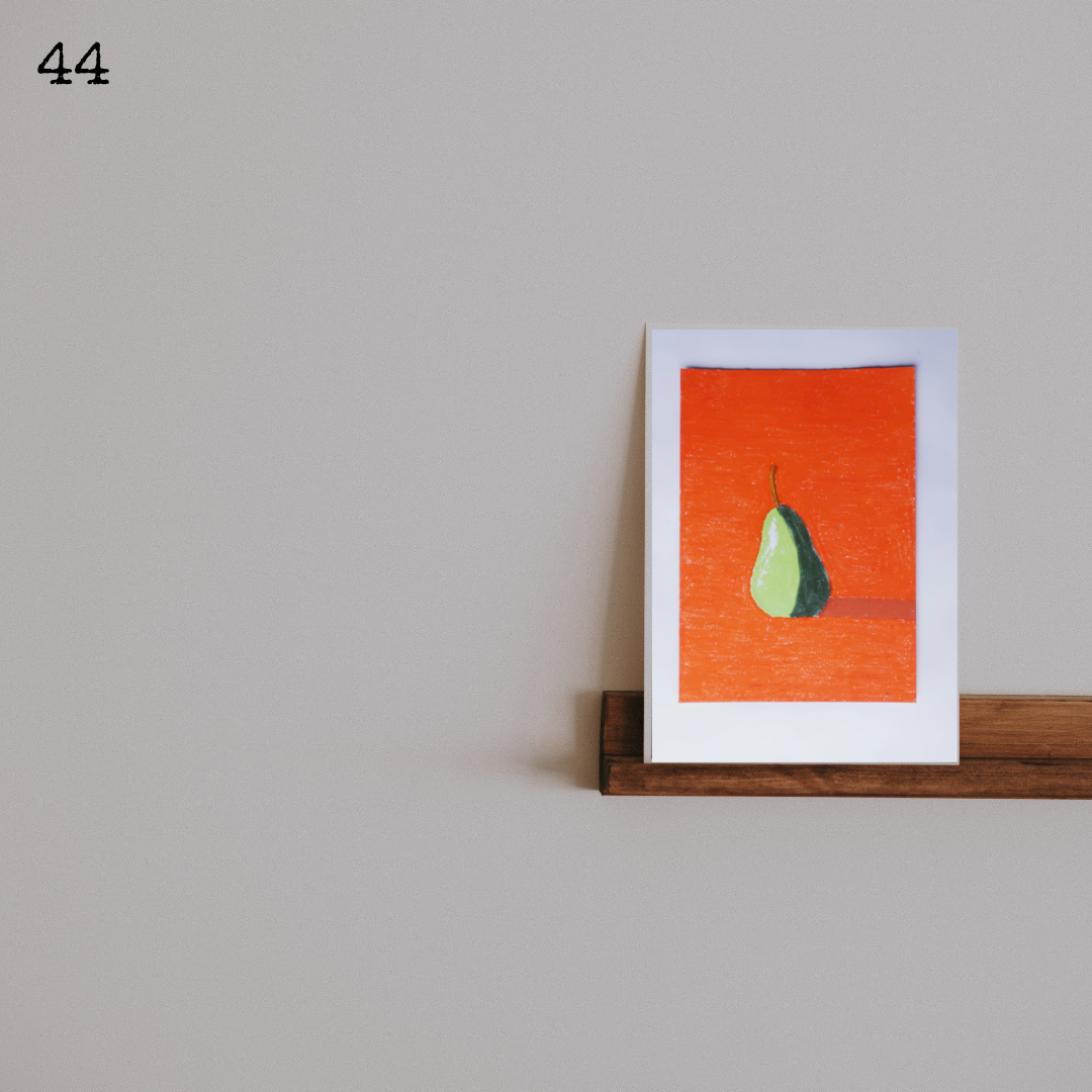 A framed oil pastel painting of a green pear against an orange background