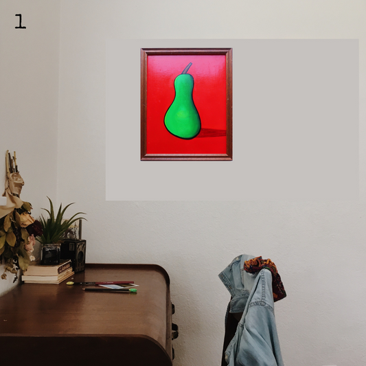 An oil painting of a green pear on a red background in a thrifted frame in a boho decor