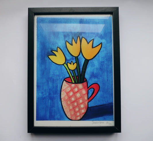 A print of an oil painting of yellow tulips in a pink mug against a blue background