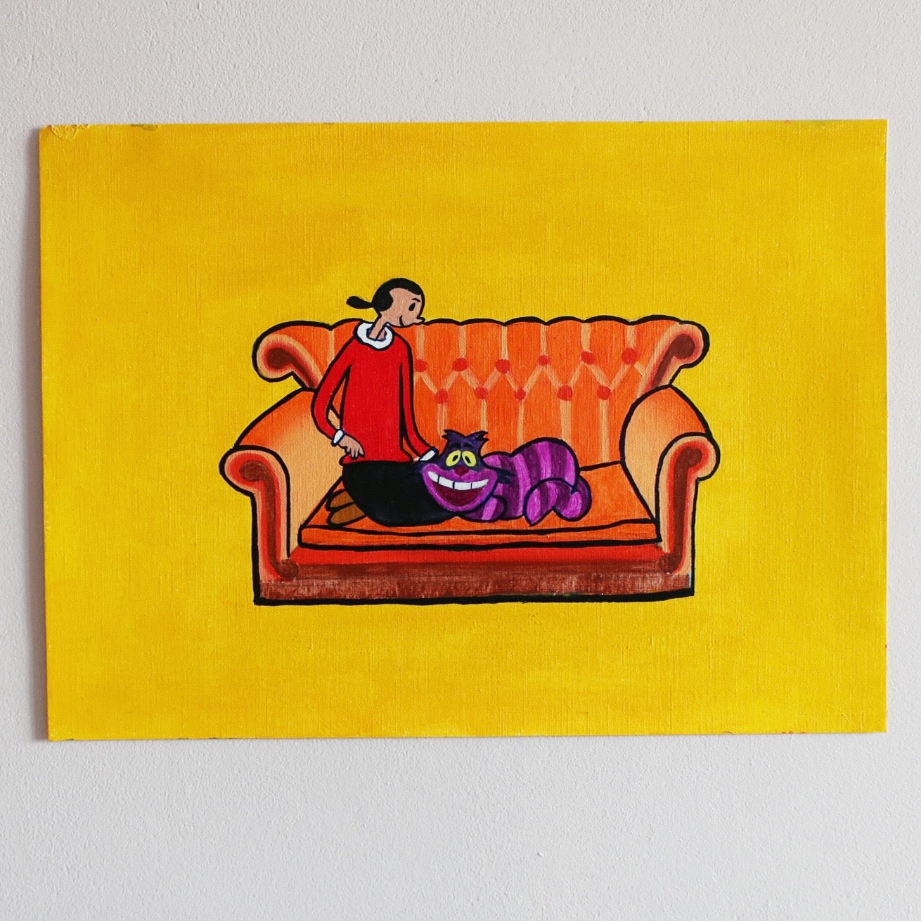 A happy art painting of Olive Oyl sitting on Friends couch stroking the Cheshire Cat of Alice in Wonderland against a yellow background on a white wall