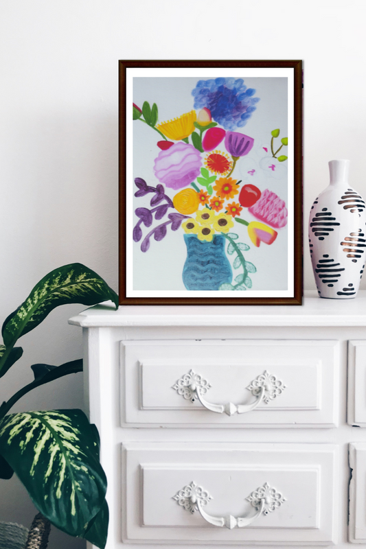 A framed oil painting of a colourful bouquet of flowers on a white drawer
