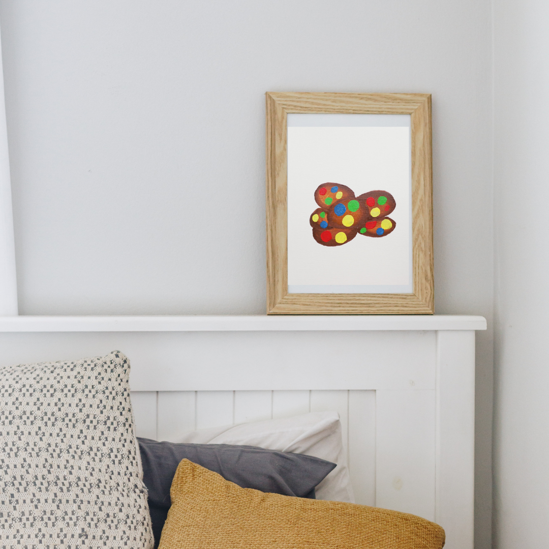 A framed painting of chocolate cookies with colourful M&Ms