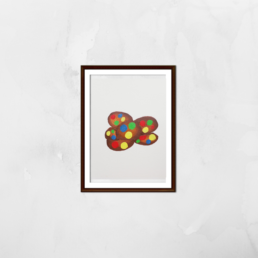 A framed painting of chocolate cookies with colourful M&Ms on a white wall