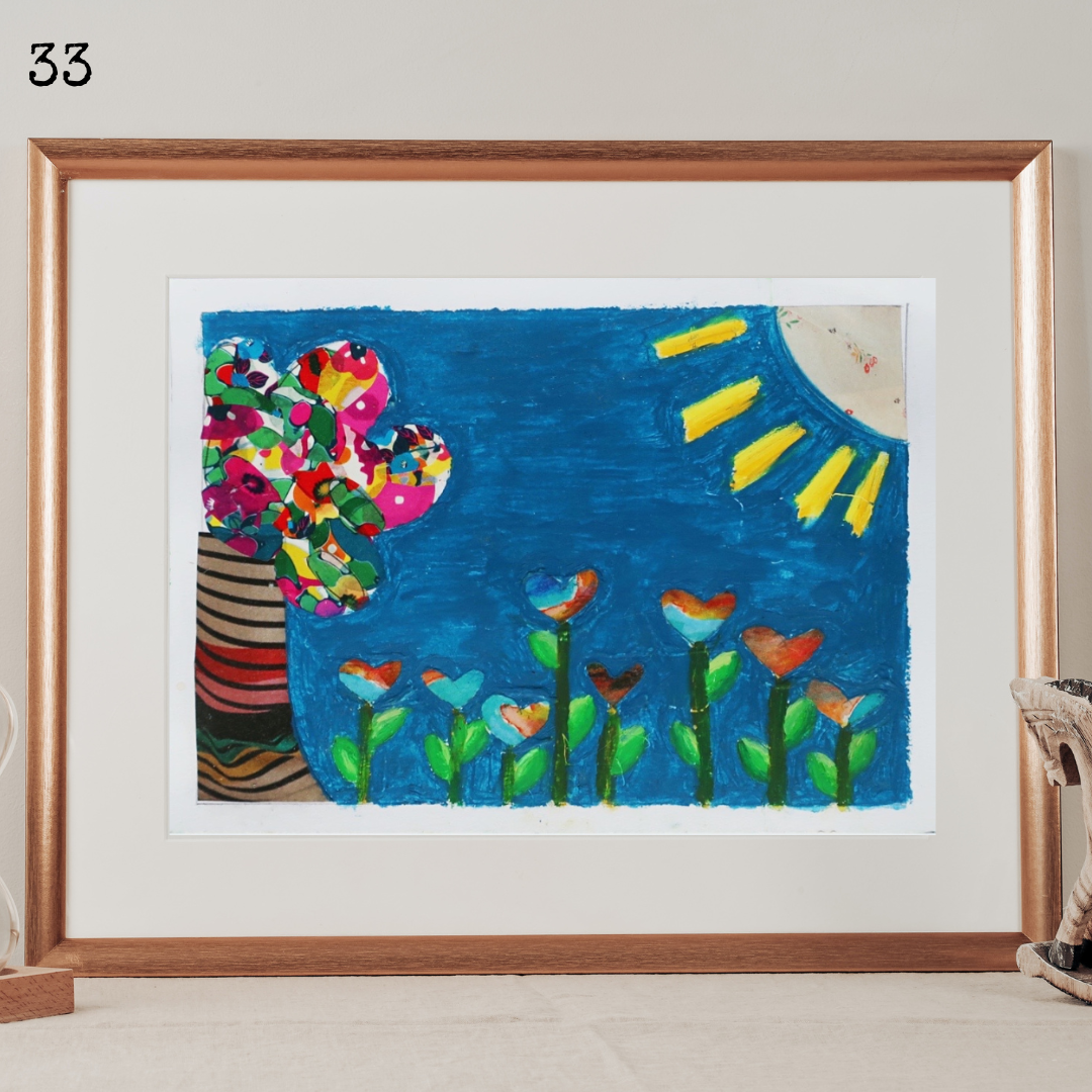 A framed mixed media collage and oil pastel representing a tree and a field of heart-shaped flowers under a blue sky and a bright sun