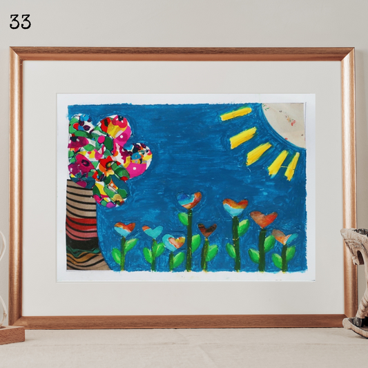 A framed mixed media collage and oil pastel representing a tree and a field of heart-shaped flowers under a blue sky and a bright sun