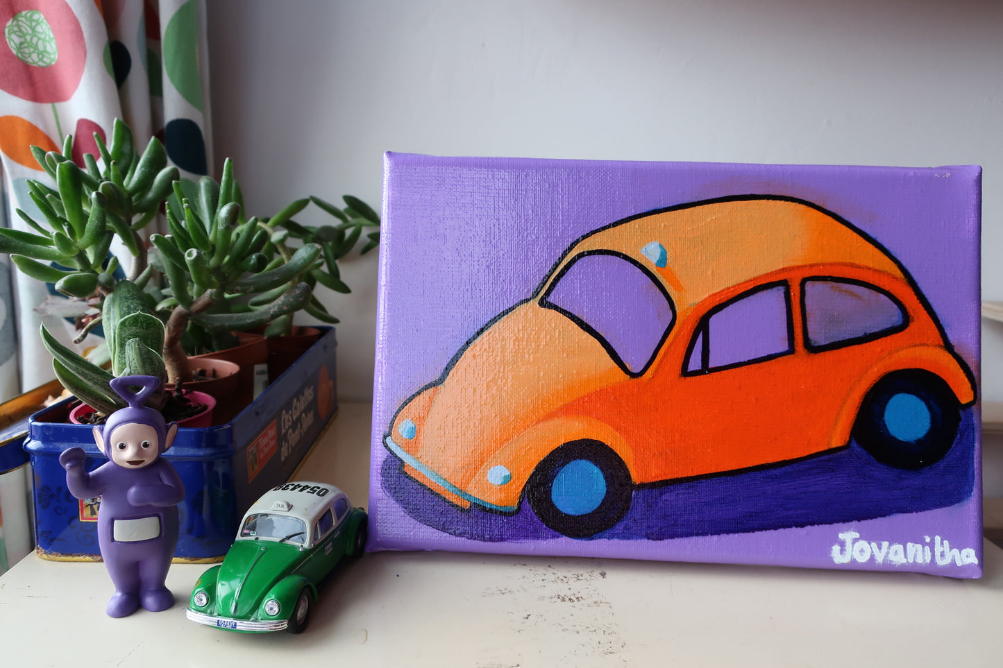 An oil painting of an orange VW Beetle car against a violet background on a white shelf
