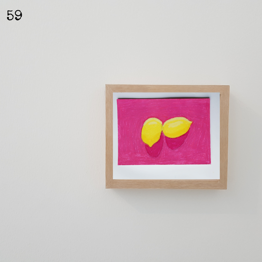 A wooden framed oil pastel painting of two yellow lemons against a pink background
